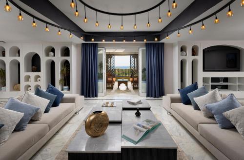 a living room with white furniture and blue pillows at Verdi Tunis Beach Resort in Gammarth