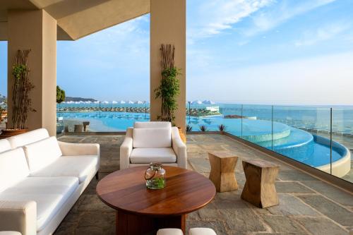 a living room with a view of a pool at Leptos Panorama Hotel in Kalamaki Chanion