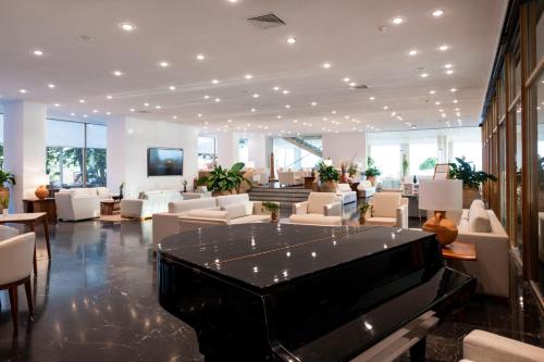 a large lobby with a piano in the middle at Leptos Panorama Hotel in Kalamaki Chanion