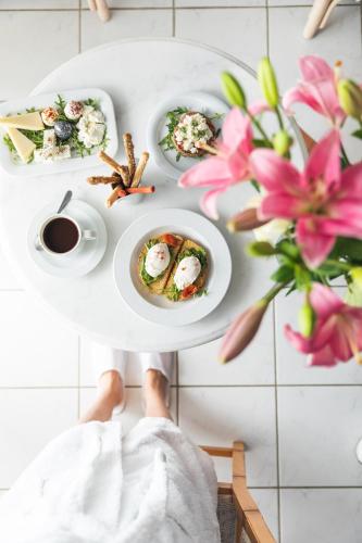 a person holding a plate of food on a table at Leptos Panorama Hotel in Kalamaki Chanion