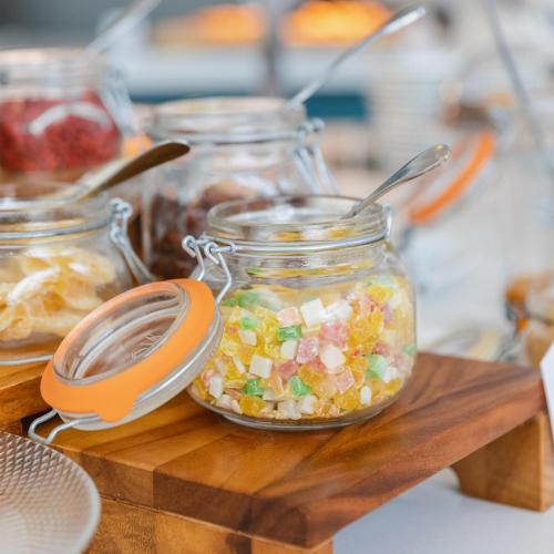 a jar of salad with an orange spoon in it at Leptos Panorama Hotel in Kalamaki Chanion