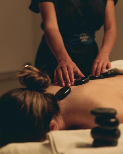 a woman is cutting a mans back with scissors at Leptos Panorama Hotel in Kalamaki Chanion