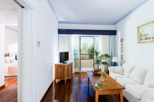 a living room with a white couch and a table at Leptos Panorama Hotel in Kalamaki Chanion