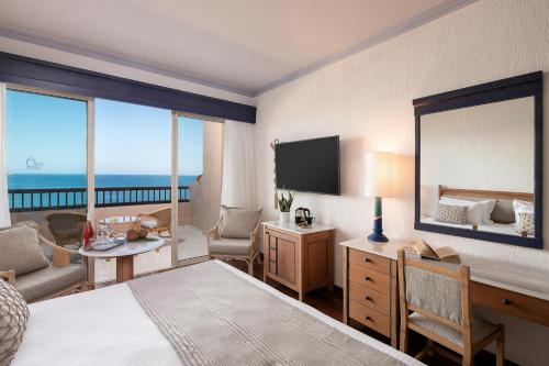 a hotel room with a bed and a large mirror at Leptos Panorama Hotel in Kalamaki Chanion