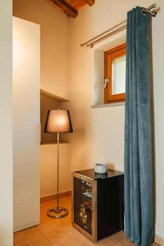 a room with a blue curtain and a lamp at Tenuta Borgo Santa Cecilia in Gubbio