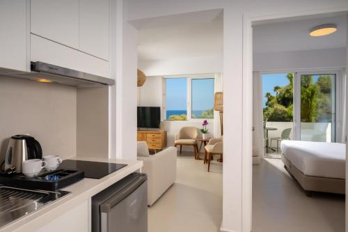 a kitchen and living room with a bedroom and a bed at Leptos Panorama Hotel in Kalamaki Chanion