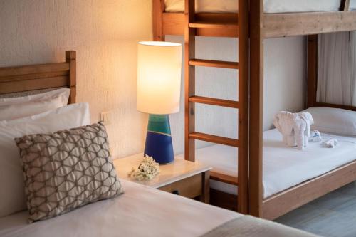 a bedroom with two bunk beds and a lamp at Leptos Panorama Hotel in Kalamaki Chanion