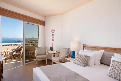 a hotel room with a bed and a balcony at Leptos Panorama Hotel in Kalamaki Chanion
