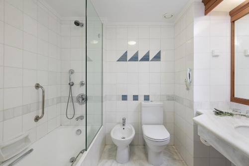 a bathroom with a toilet and a shower and a sink at Leptos Panorama Hotel in Kalamaki Chanion