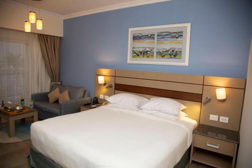 pokój hotelowy z dużym łóżkiem i krzesłem w obiekcie Swiss Inn Resort Hurghada w mieście Hurghada