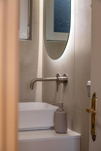 a bathroom with a white sink and a mirror at Filoxenia Apartments in Mytilini
