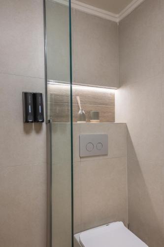 a bathroom with a toilet and a glass shower stall at Filoxenia Apartments in Mytilini