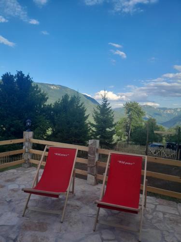 two red chairs sitting on a patio with mountains in the background at Wild peace Vladimir in Foča