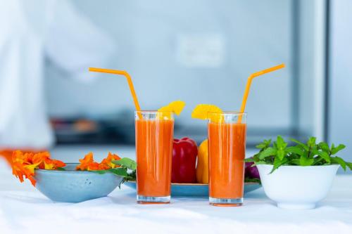 three glasses of orange juice and a plate of fruit at B&P Ever Retreat Villa Gisenyi in Gisenyi