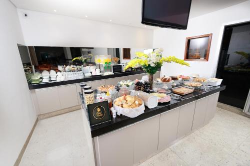 a buffet in a hotel with food on a counter at Hotel Portela II - Av Principal e a 500m do Thermas dos Laranjais in Olímpia