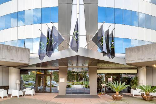 a building with flags hanging off the side of it at B&B HOTEL Bergamo Executive in San Paolo D'Argon