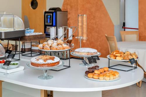 a table filled with different types of pastries and cakes at B&B HOTEL Bergamo Executive in San Paolo D'Argon