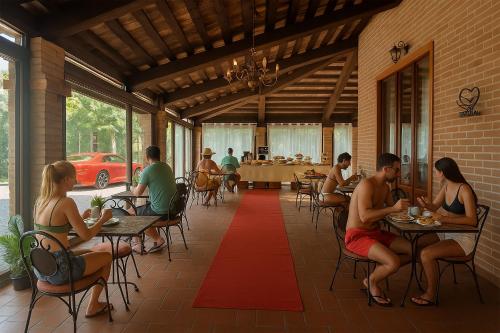 eine Gruppe von Menschen, die an Tischen in einem Restaurant sitzen in der Unterkunft Villa Ferrara Royal Resort & Spa in Coriano