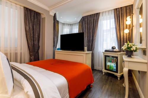 a hotel room with a bed and a flat screen tv at Amiral Palace Hotel Boutique Class in Istanbul