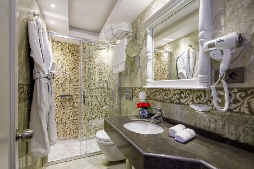 a bathroom with a sink and a shower and a toilet at Amiral Palace Hotel Boutique Class in Istanbul