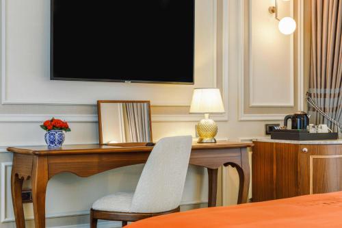 a desk with a chair and a television on a wall at Amiral Palace Hotel Boutique Class in Istanbul