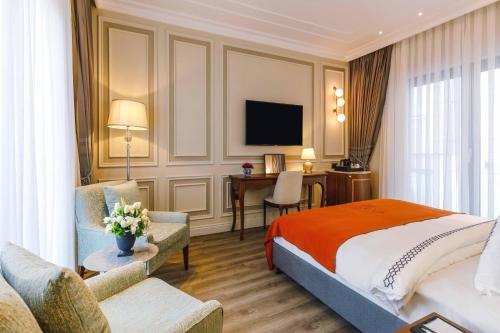 a hotel room with a bed and a desk and a television at Amiral Palace Hotel Boutique Class in Istanbul