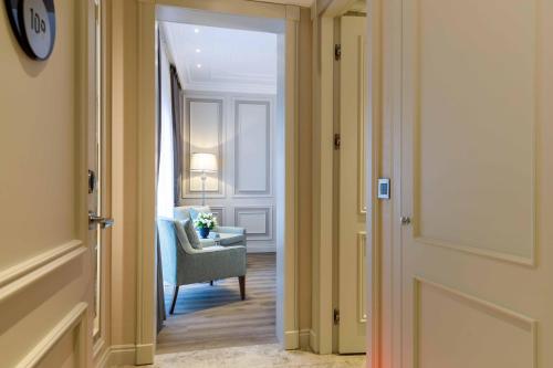 an open door to a room with a blue chair and a room with a chair at Amiral Palace Hotel Boutique Class in Istanbul
