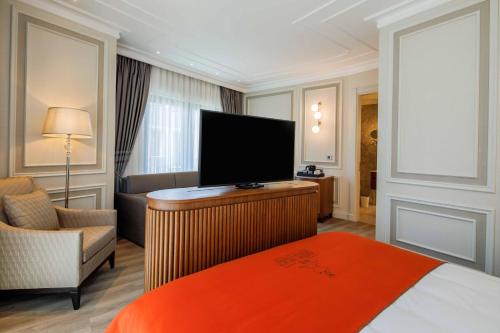 a hotel room with a bed and a flat screen tv at Amiral Palace Hotel Boutique Class in Istanbul