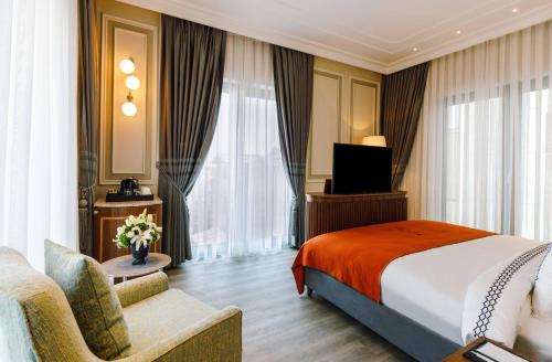 a hotel room with a bed and a couch and a television at Amiral Palace Hotel Boutique Class in Istanbul