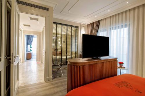a bedroom with a flat screen tv on top of a bed at Amiral Palace Hotel Boutique Class in Istanbul