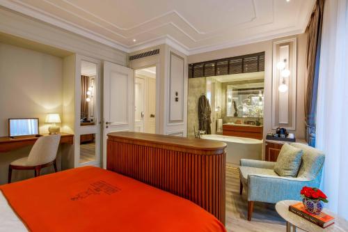 a bedroom with an orange bed and a bathroom at Amiral Palace Hotel Boutique Class in Istanbul