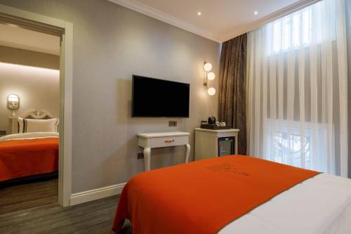 a hotel room with a bed and a flat screen tv at Amiral Palace Hotel Boutique Class in Istanbul