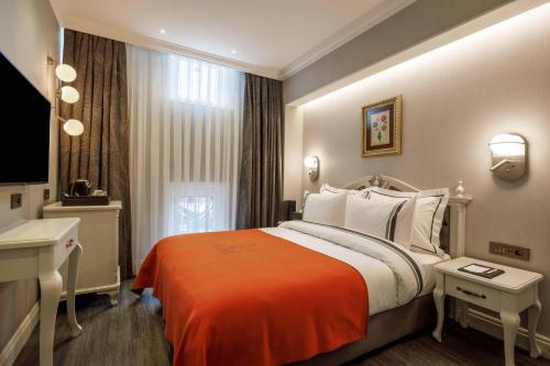 a hotel room with a large bed and a sink at Amiral Palace Hotel Boutique Class in Istanbul