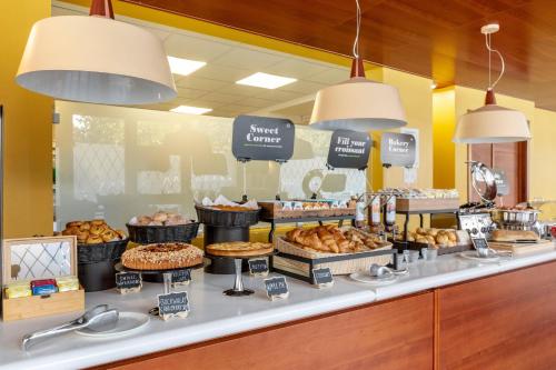 a bakery counter with various pastries and pies at B&B Hotel Modena in Modena