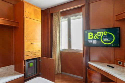 a kitchen with a tv in a room with a window at B&B Hotel Modena in Modena