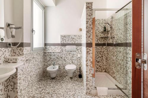 a bathroom with a toilet and a sink and a shower at B&B Hotel Modena in Modena