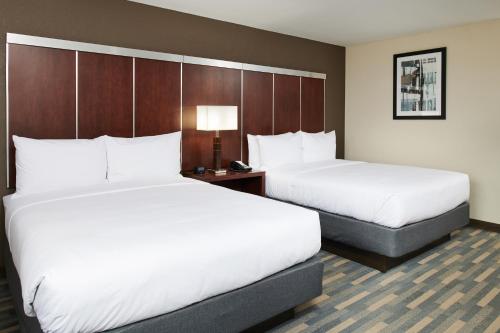a hotel room with two beds and a lamp at Doubletree By Hilton Raleigh Crabtree Valley in Raleigh