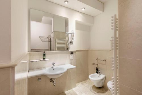 a bathroom with a sink and a toilet and a mirror at B&B Hotel Modena in Modena