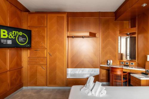 a kitchen with wooden cabinets and a sink and a counter at B&B Hotel Modena in Modena