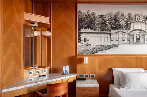 a room with a bed and a picture of a house at B&B Hotel Modena in Modena