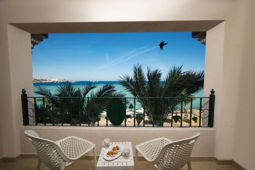 a view of the beach from a balcony with a table and chairs at Sunny Days El Palacio Resort & Spa in Hurghada