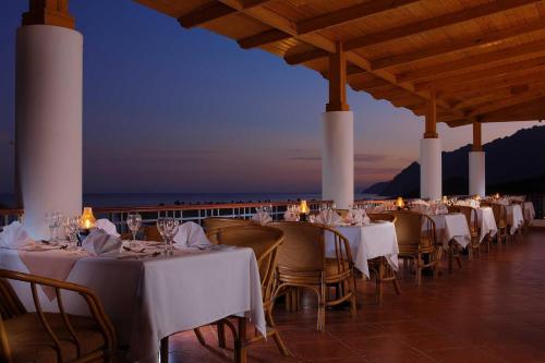 una fila de mesas con manteles y sillas blancas en Ecotel Dahab Bay View Resort, en Dahab