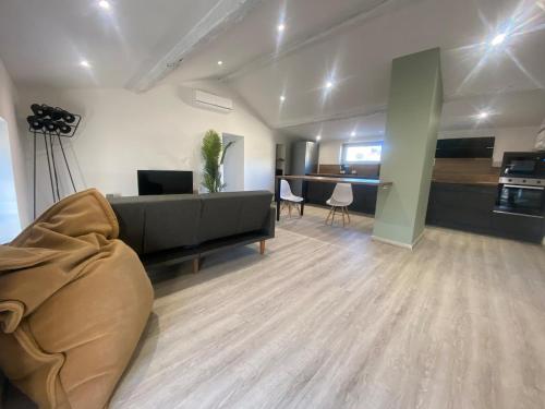 a living room with a couch and a table at Superbe Appartement Atypique Combles - Neuf avec Vue in Narbonne