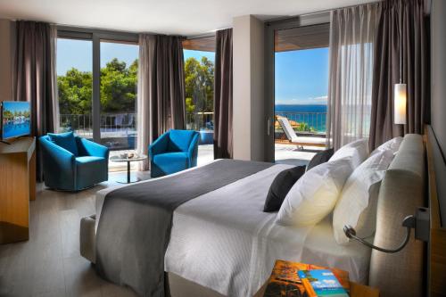 een slaapkamer met een groot bed en een groot raam bij Blue Dolphin Hotel in Metamorfosi