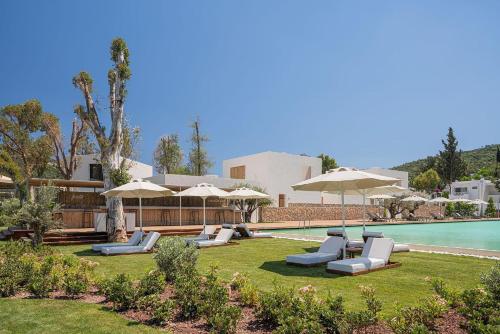 a resort with chairs and umbrellas and a swimming pool at Voyage Torba Hotel in Torba