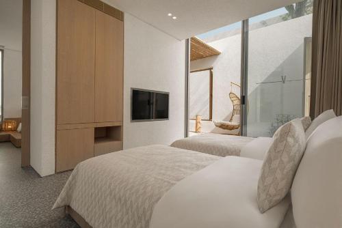 a hotel room with two beds and a television at Voyage Torba Hotel in Torba