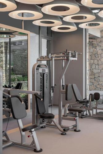 a gym with several treadmills and elliptical machines at Voyage Torba Hotel in Torba