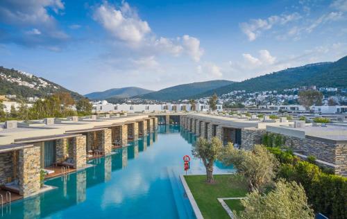 an image of a hotel pool with mountains in the background at Voyage Torba Hotel in Torba