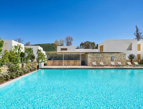 a large swimming pool in front of a building at Voyage Torba Hotel in Torba