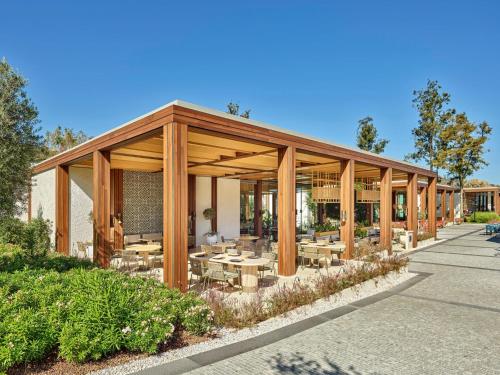 a pavilion with tables and chairs outside of a building at Voyage Torba Hotel in Torba